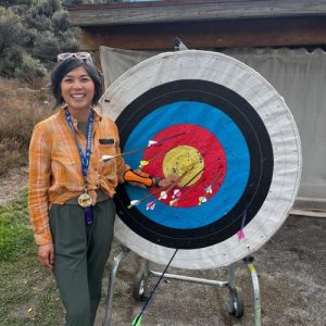 Emmy standing next to archery target