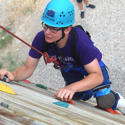 Camper ascending the climbing wall at Roundup River Ranch