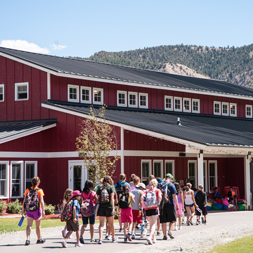 Trents cabin with campers walking towards it