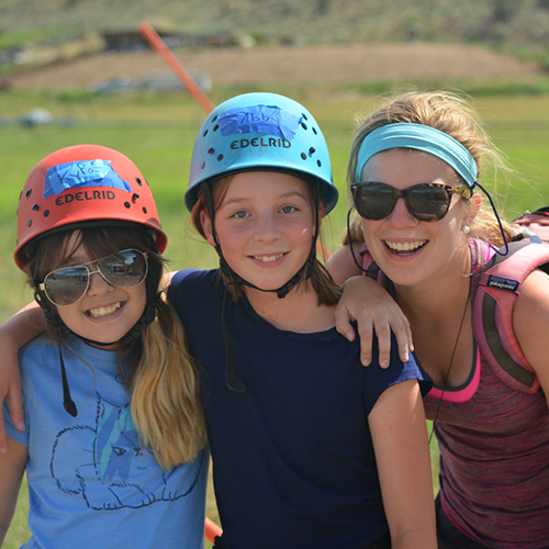 campers and volunteer smiling at camera