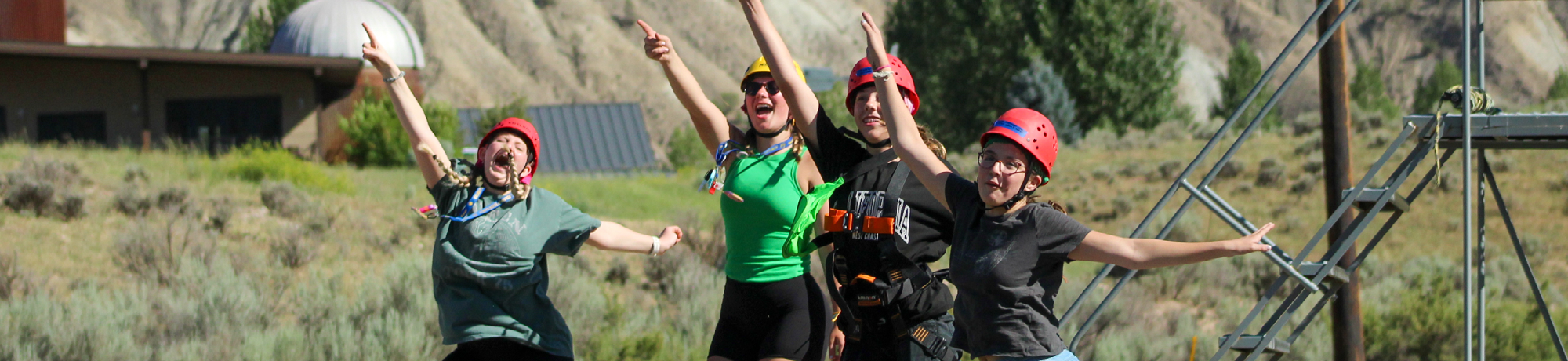 camper counselors jumping and dancing outside.
