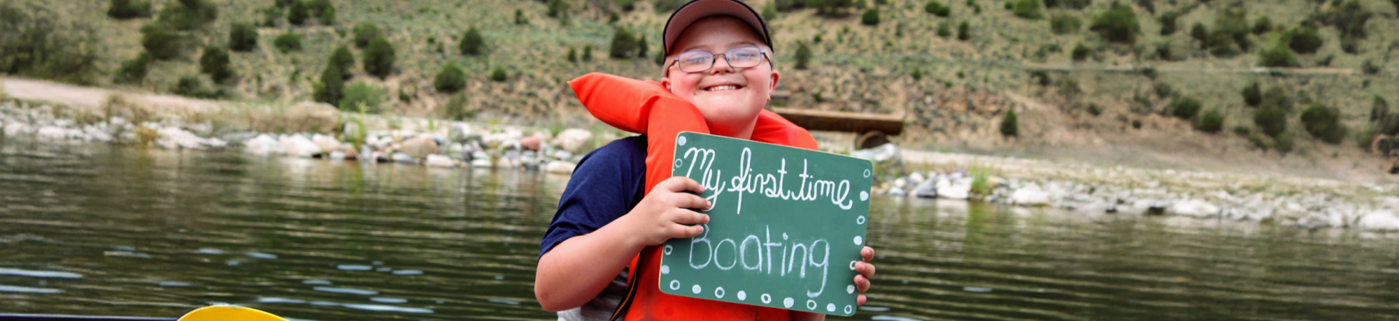 Camper in canoe with sign that says "first day boating"