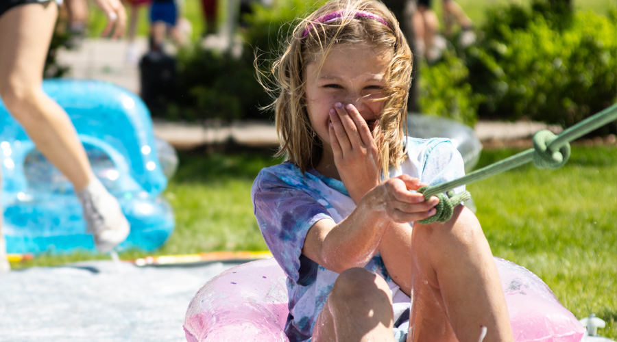camper having fun in the water and bubbbles holding a rope