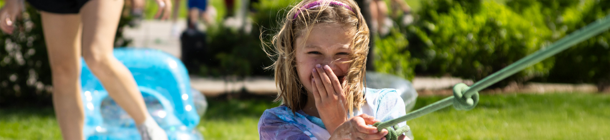 camper having fun in the water and bubbbles holding a rope