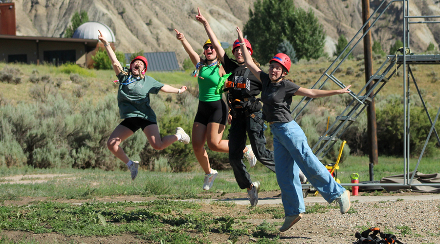camper counselors jumping and dancing outside.