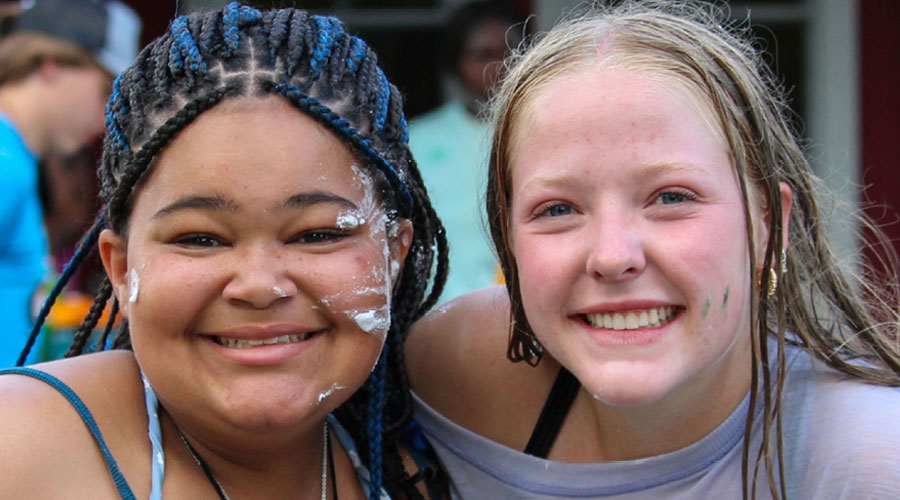 Two teen female campers smiling at the camera.